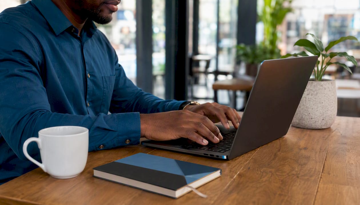 Hands installing WordPress SEO plugin on laptop