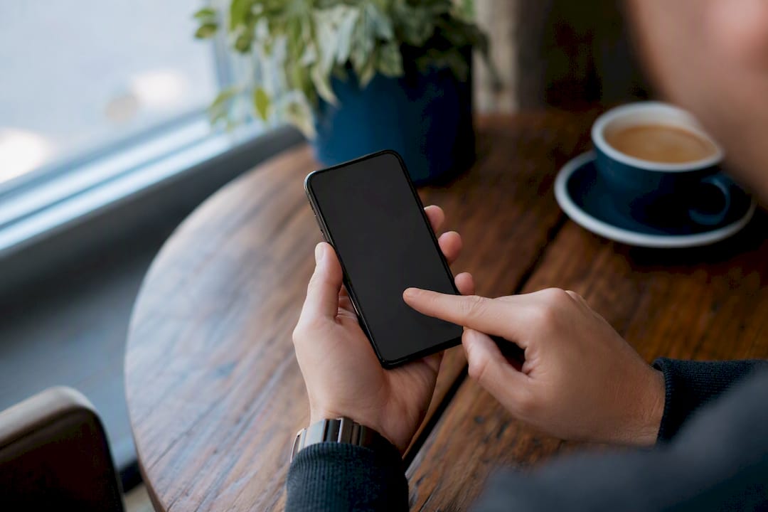 Hands tapping smartphone to update profile